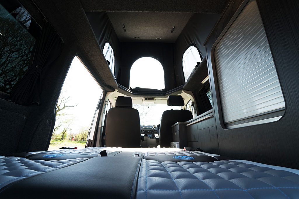 In the rear interior area of the van with view of the bed area